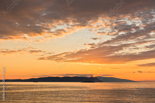 Sun is setting behind Skiathos island, view from Kastani Mamma Mia beach, island of Skopelos, Greece © banepetkovic