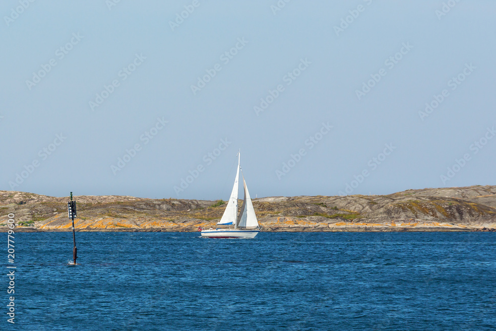 Fototapeta premium Sailingboat at a rocky coastline