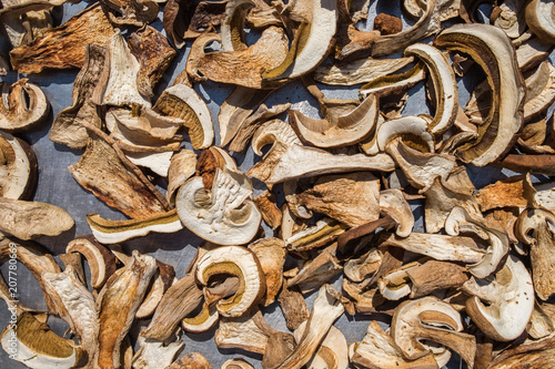 Sliced fresh Boletus Edulis mushrooms on metal surface. Drying process under sunlight. 