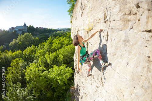 The woman climbs the rock.