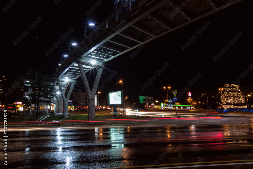 BURGAS, BULGARIA - FEBRUARY 4, 2018: circular motion at the crossroads. Overhead pedestrian bridge at night