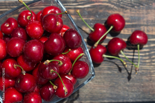 red cherries in a glass vase on a dark background photo