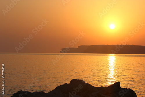 a beautiful view of Gozo Island in the distance at sunset  Malta