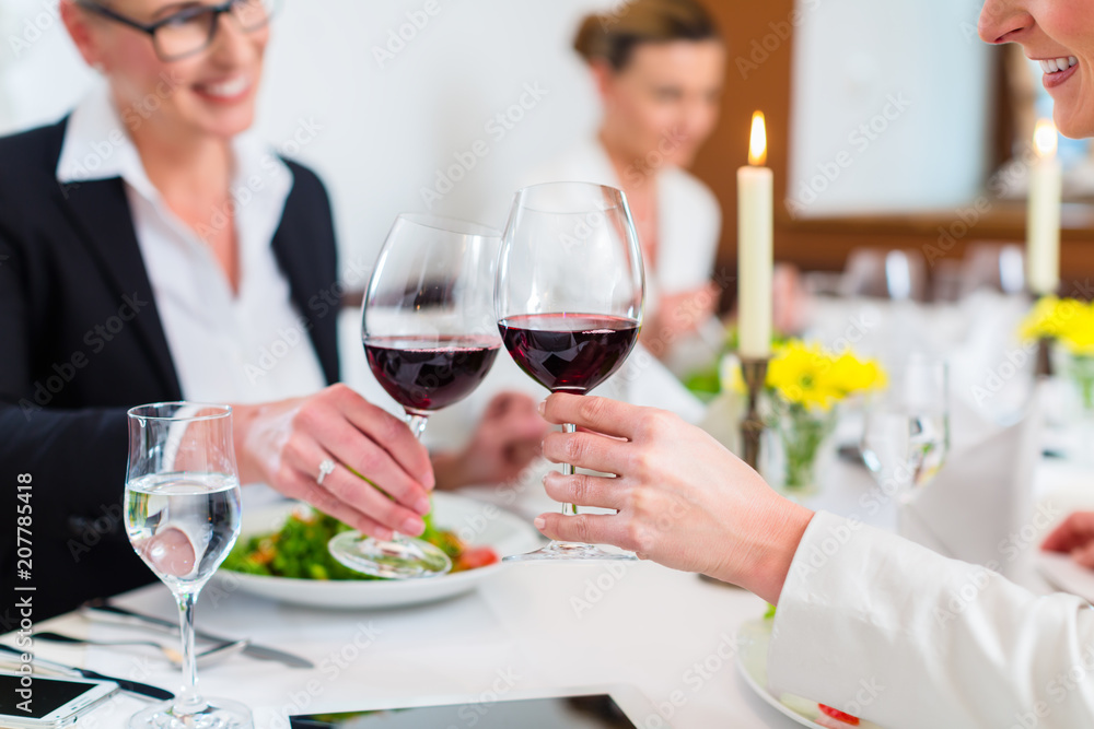 Women on business lunch toasting with wine to celebrate an agreement Women on business lunch toasting with wine to celebrate an agreement