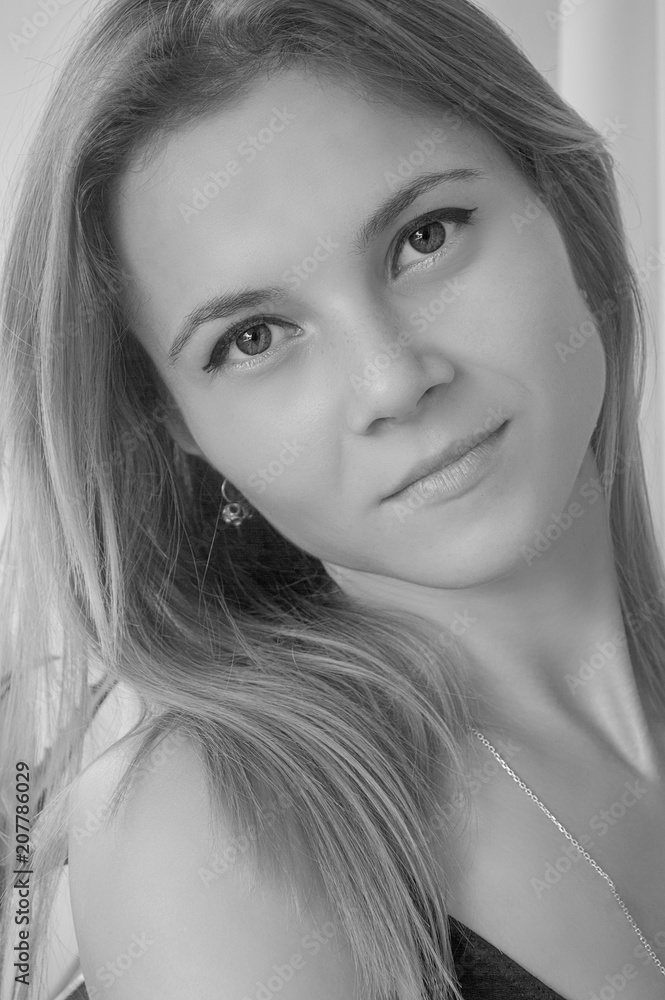 Naklejka premium Black and white portrait of a slender and young girl in natural daylight.