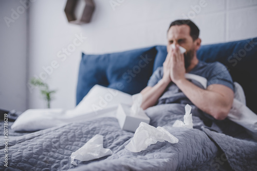 Man sneezing in napkin photo