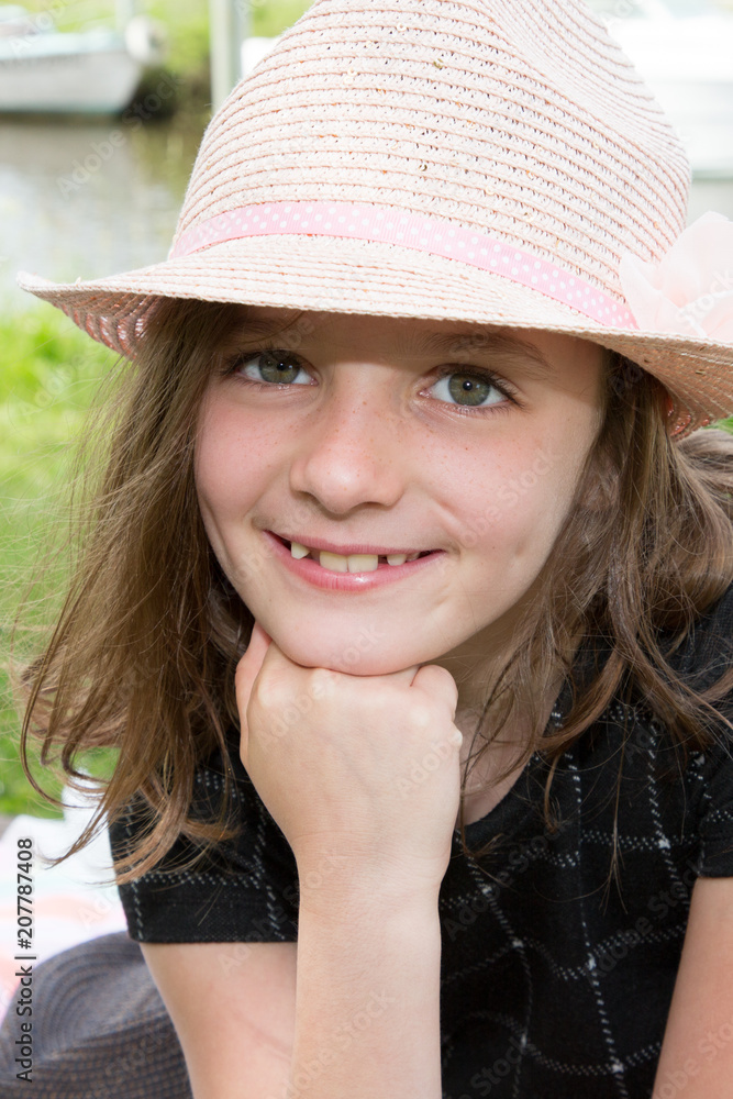 Outdoor Portrait of a Thoughtful LIttle Girl with hat