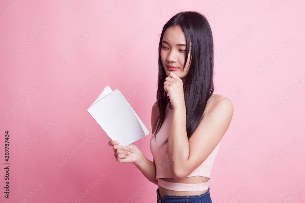 Young Asian woman with a book is thinking. Young Asian woman with a book is thinking.