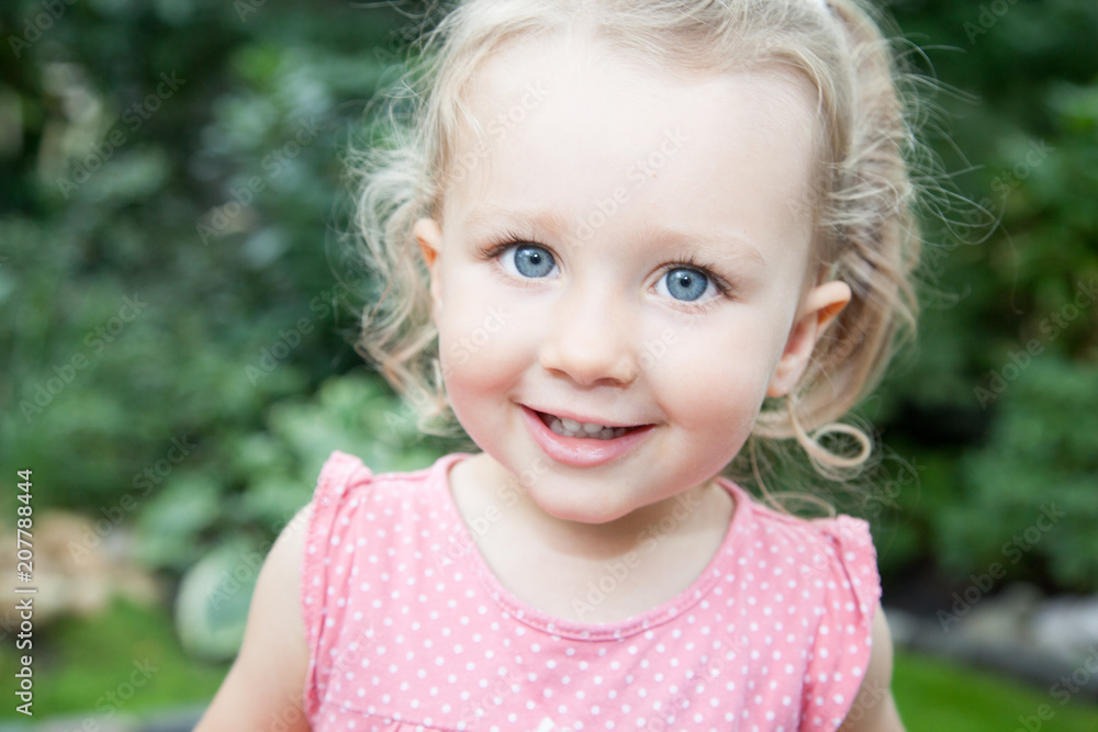 Happy smiling blonde cute girl outdoor with lagre big blue eyes Happy smiling blonde cute girl outdoor with lagre big blue eyes