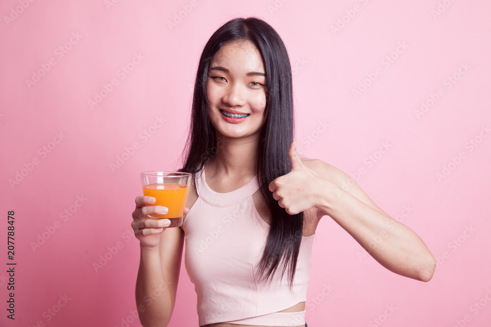 Young Asian woman thumbs up drink orange juice. Young Asian woman thumbs up drink orange juice.