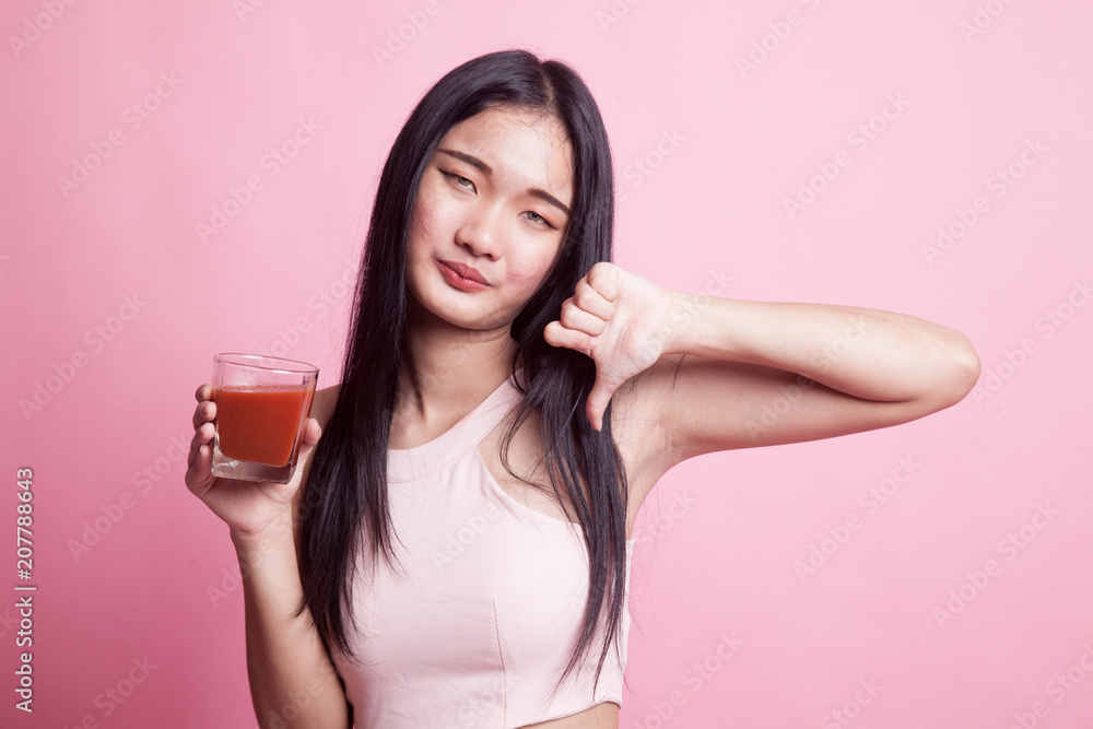 Asian woman thumbs down hate tomato juice. Asian woman thumbs down hate tomato juice.