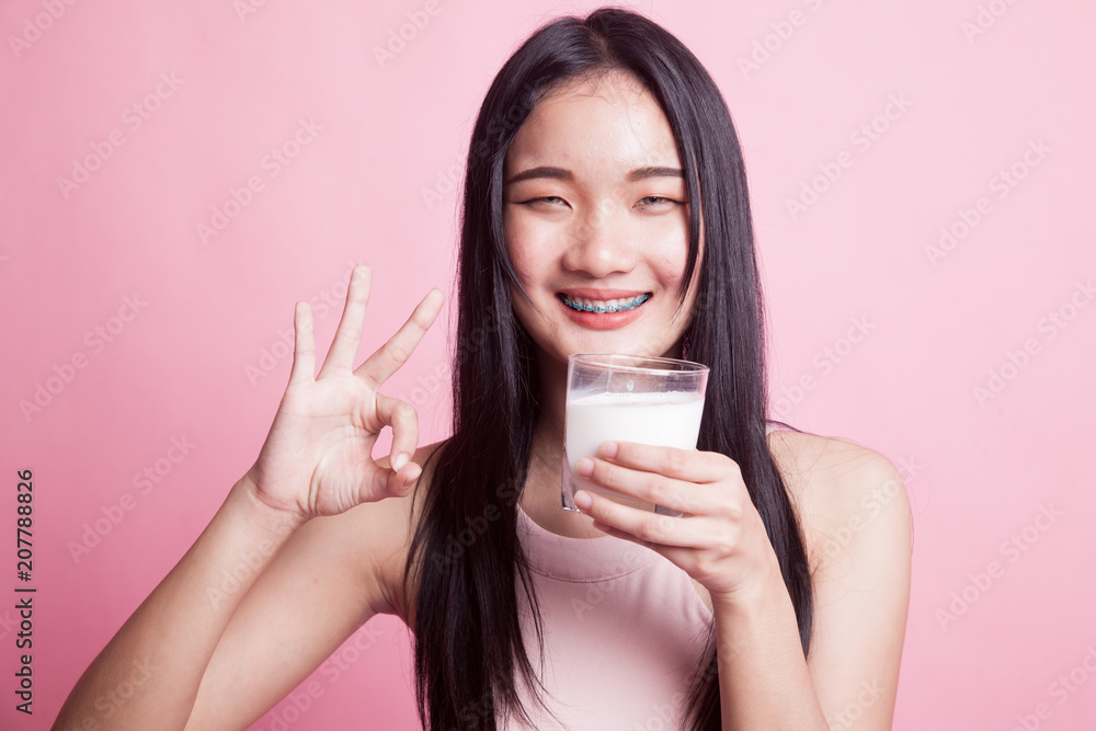 Healthy Asian woman drinking a glass of milk show OK sign. Healthy Asian woman drinking a glass of milk show OK sign.