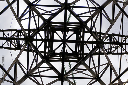 symmetrical pattern formed by a bottom view of a steel grid-shaped power line support