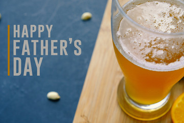 Happy father's day graphic with pint of beer and snacking peanuts in background.  Text for holiday card or banner on black background.
