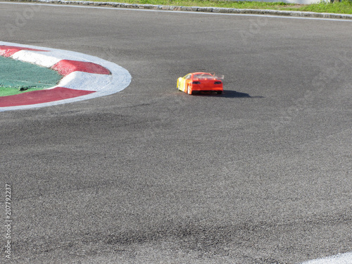 Small radio controlled model car on the track . Miniature remote controlled sport racing cars hobby