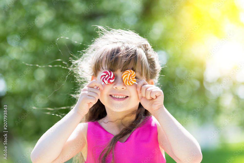 The little girl closed her eyes with sugar candies. The girl playing brought sweet sweets to her eyes and closed them. The little girl closed her eyes with sugar candies. The girl playing brought sweet sweets to her eyes and closed them.