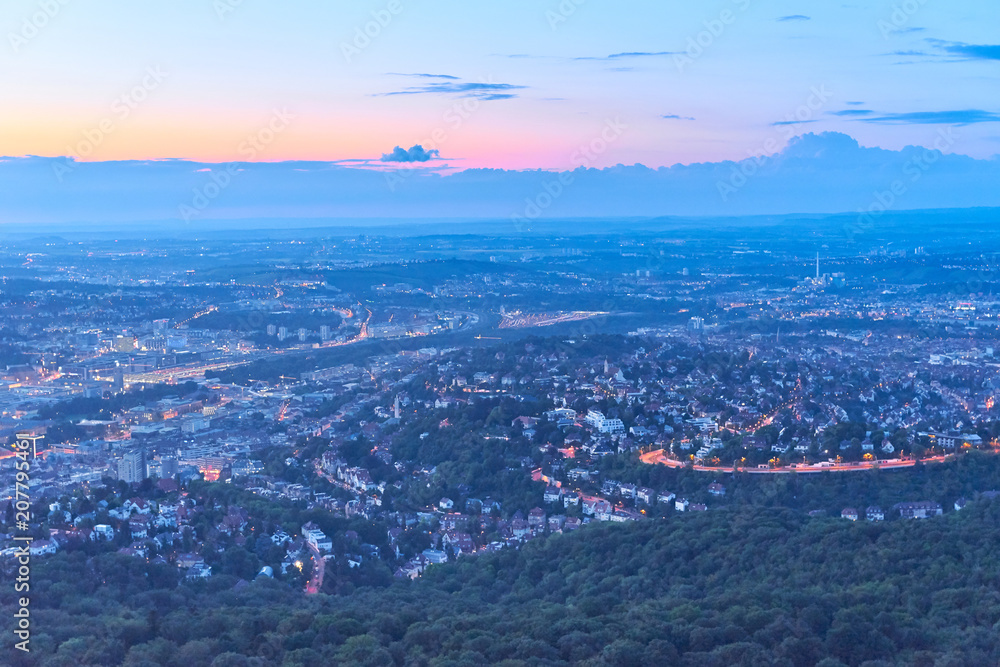 Night falls over Stuttgart City in Germany / Turning on the lights in the city