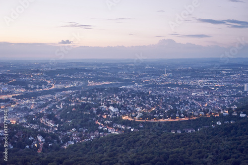 Night falls over Stuttgart City in Germany / Turning on the lights in the city