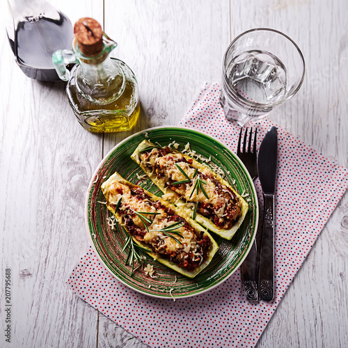 Stuffed zucchini on a green plate on the table photo