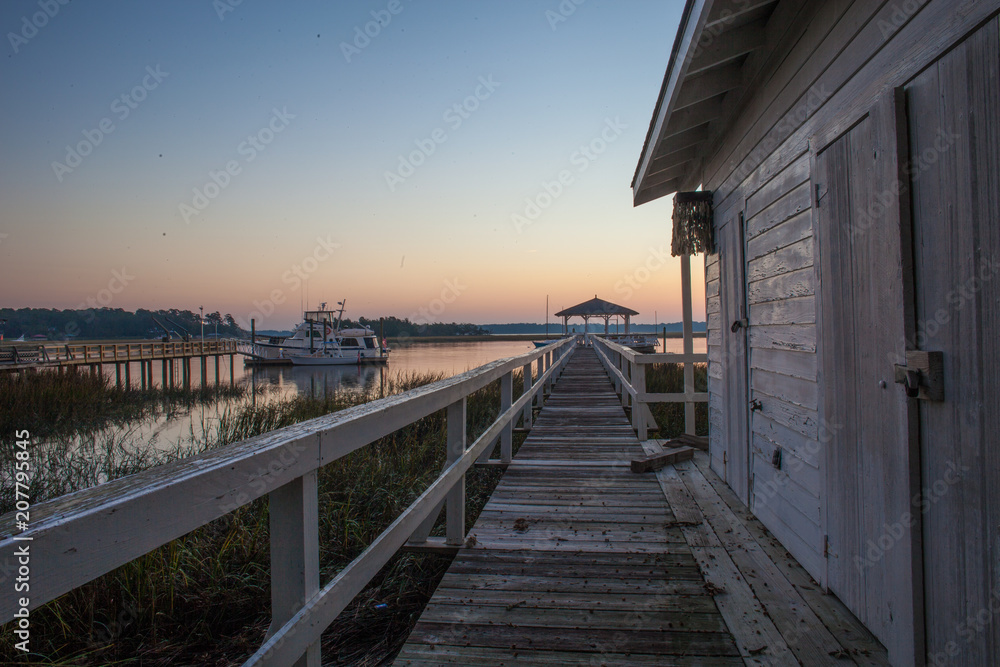 Sunrise over the marsh with a wooden dock and water