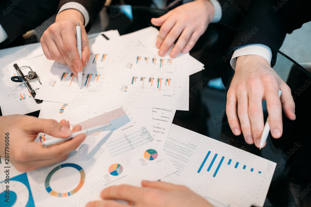 business documents review. man pointing at some important data with a finger. statistics papers analysis. investment rates discussion business documents review. man pointing at some important data with a finger. statistics papers analysis. investment rates discussion