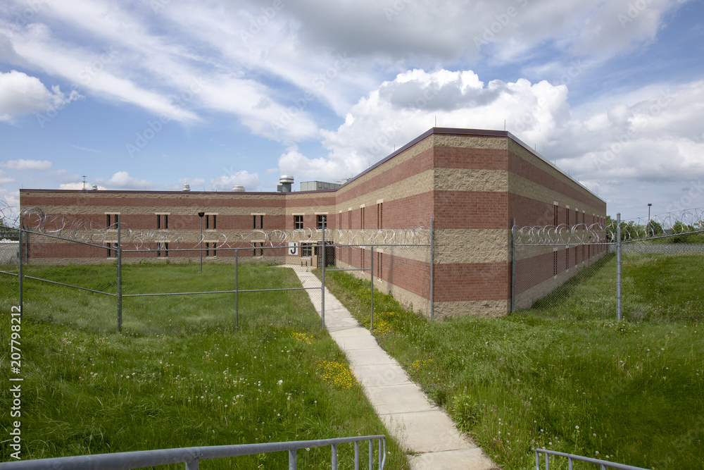 Exterior of prison cell block with overgrown yard
