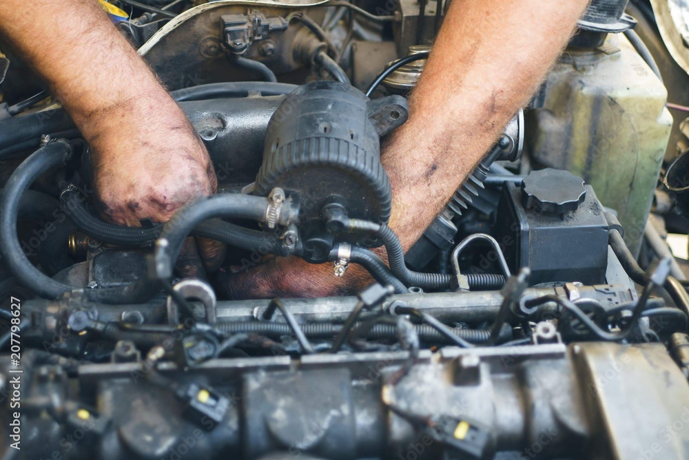 Close-up of mechanic repairing an engine. Man hands in oil Close-up of mechanic repairing an engine. Man hands in oil