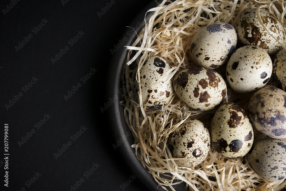 some quail eggs in a black ceramic bowl some quail eggs in a black ceramic bowl