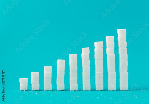 Financial chart made of sugar cubes with blue background. Sugar consumption growth rate world market concept.