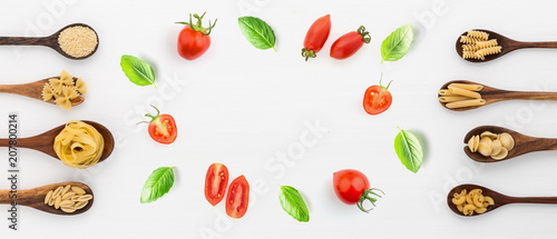 Panoramic view different kind of pasta on wooden spoon and ingredients on white background from top view. Italian food concept. Banner