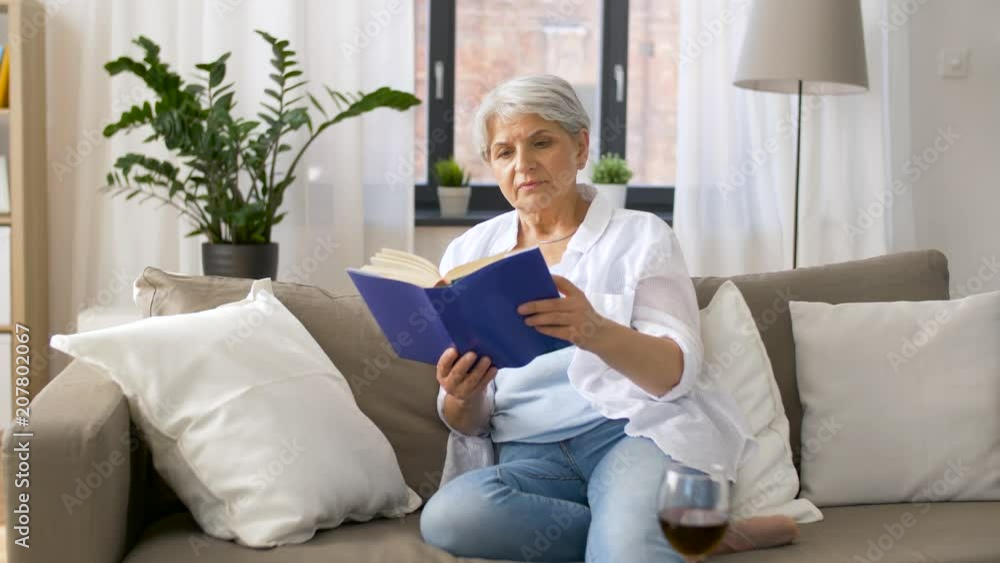 age, leisure and people concept - senior woman reading book at home age, leisure and people concept - senior woman reading book at home