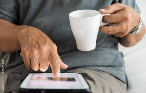 Senior male hands using a digital tablet.