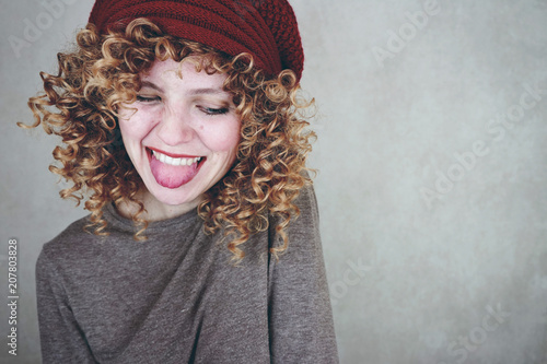 Preciosa y divertida mujer rubia con el pelo rizado que sonríe para la foto photo