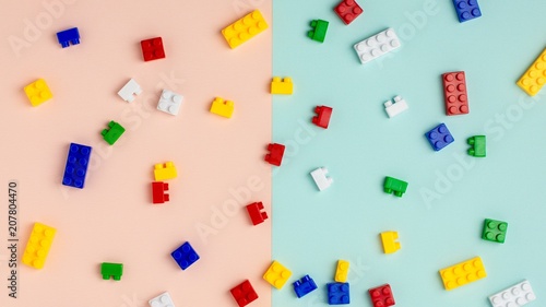 Plastic building blocks on blue and pink background