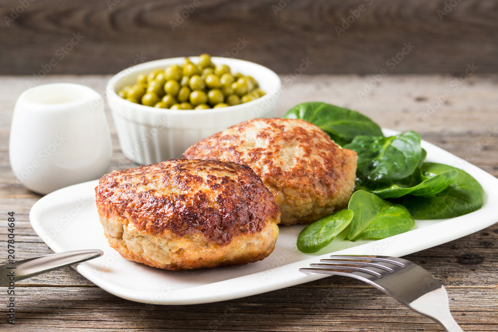Homemade cutlets with a salad on a plate in a rustic style. Homemade cutlets with a salad on a plate in a rustic style.