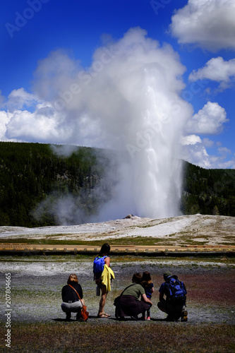 Family Watching Old Faithful in Yellowstone National Park in American West