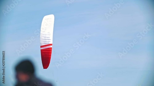 Flying sail in blue sky with kiteboarder over the river