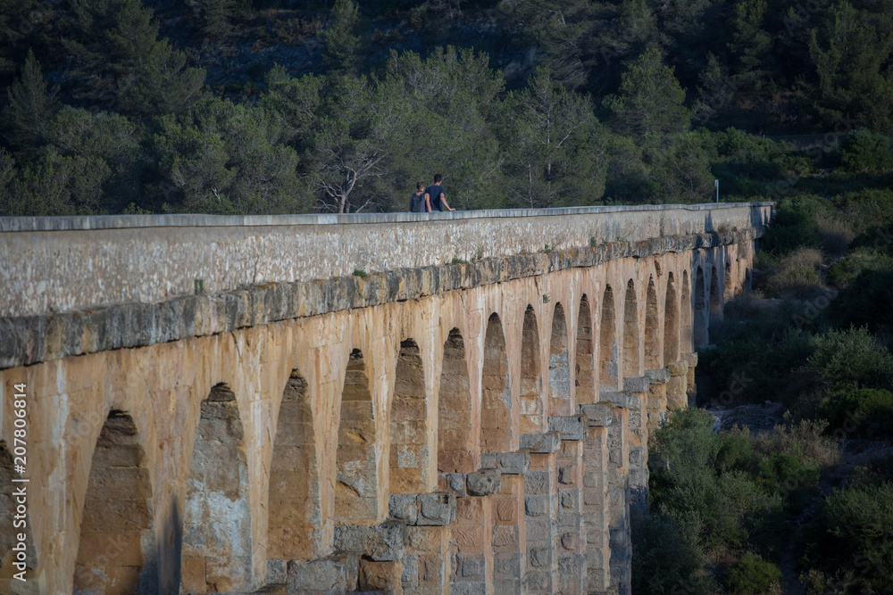 Ancient viaduct bridge from the bottom view in the setting sun