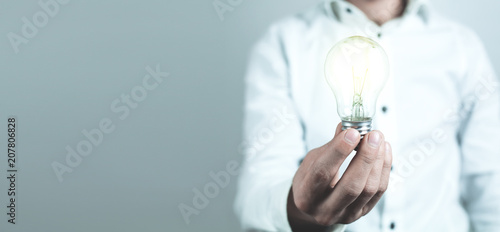 Businessman holding light bulb. Concept of new idea