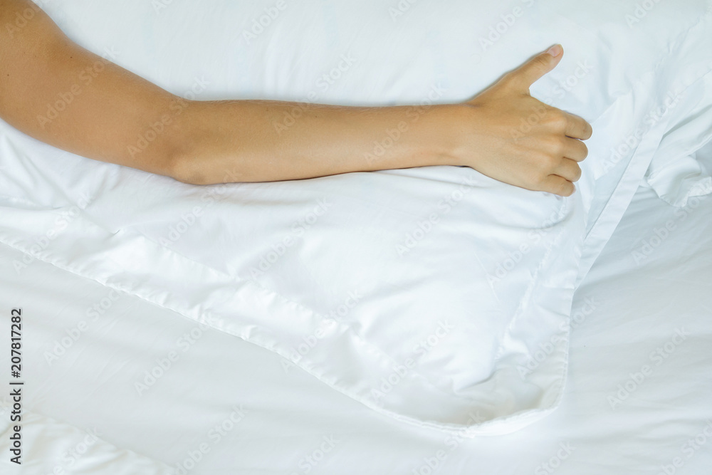 Lonely female hand on the soft bed linen Lonely female hand on the soft bed linen