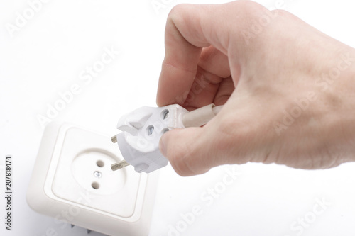 close up of a hand including a fork in an electrical outlet.