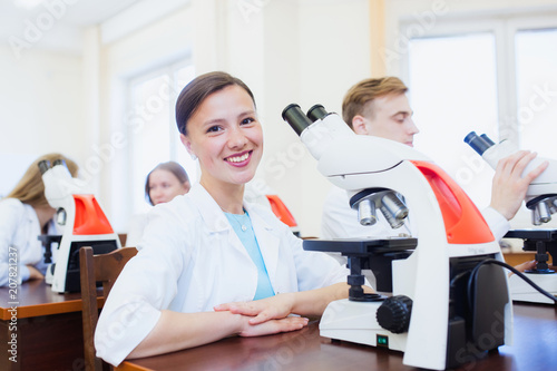 High school students using microscopes in laboratory