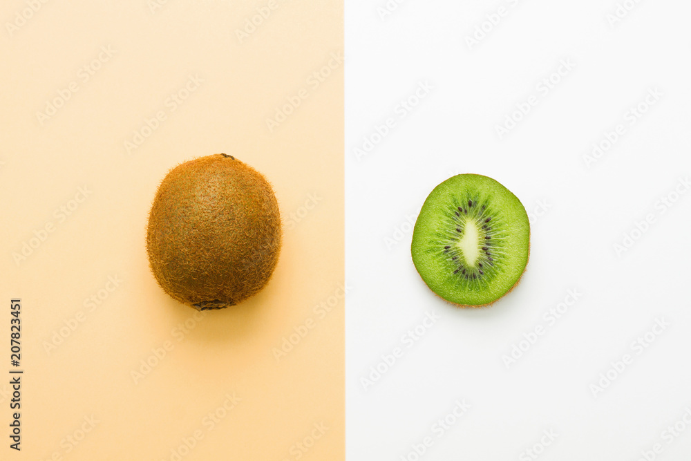 Obraz premium Fresh kiwi whole fruit and slice on orange white background
