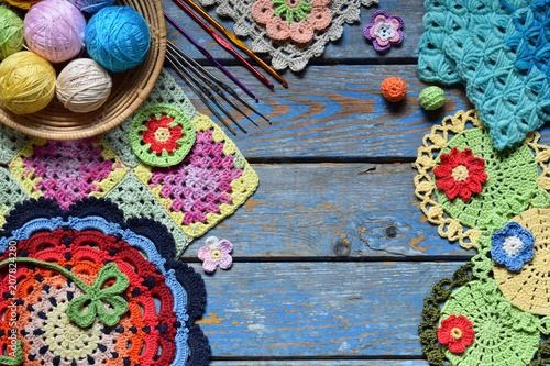 Equipment for knitting and crochet hook, colorful rainbow cotton yarn, ball of threads, wool, knitted elements, napkin . Granny square. Handmade crocheting crafts. DIY concept. Copy space photo