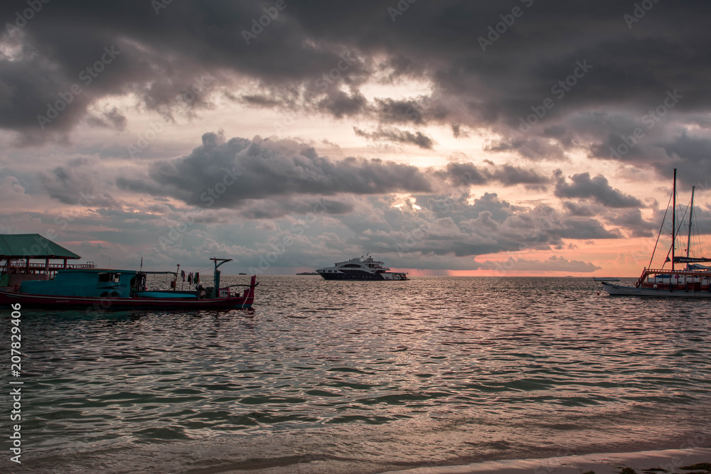 Gorgeous view of sunset on Indian Ocean, Maldives. Some boats on horizon line. Amazing nature landscape background.