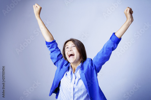 Portrait of a very happy woman.  Winner gesture (body language comncept) photo