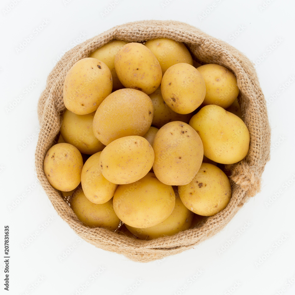 Sack of fresh raw potatoes on wooden background, top view Sack of fresh raw potatoes on wooden background, top view