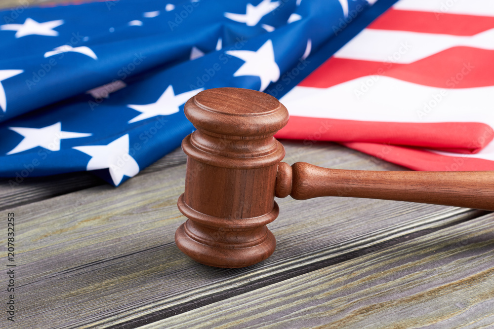 Justice gavel on wooden background. Close up judge gavel and USA flag on wooden table. Legal system of the USA.