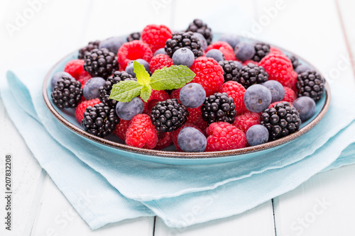 Fresh raspberries in a plate on a  vintage background.