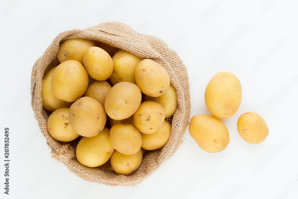 Sack of fresh raw potatoes on wooden background, top view Sack of fresh raw potatoes on wooden background, top view